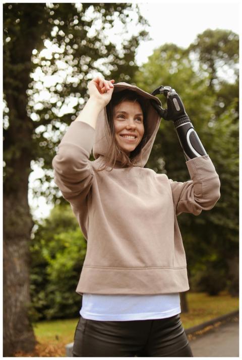 Smiling woman with prosthetic arm enjoying a day o