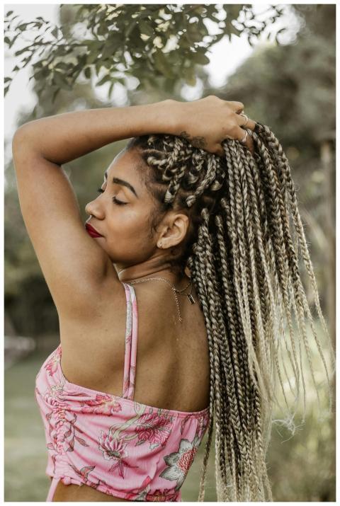 Woman with braided hair in a pink top enjoying out