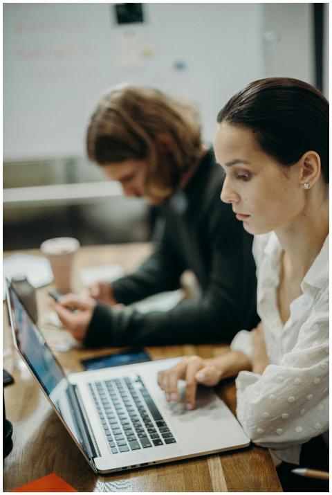 Two professionals working together at a laptop in