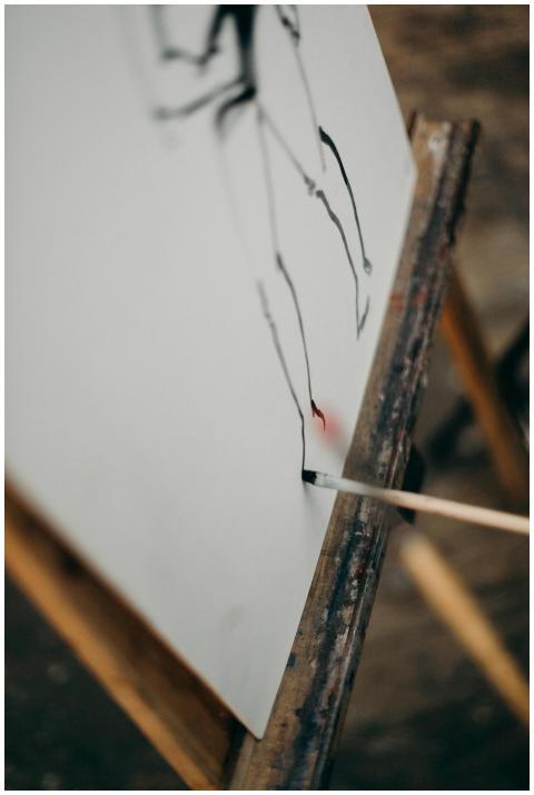 Close-up of a paintbrush applying strokes on a can
