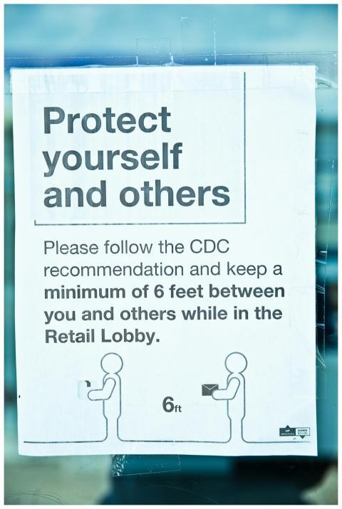 A sign displaying CDC guidelines for social distan