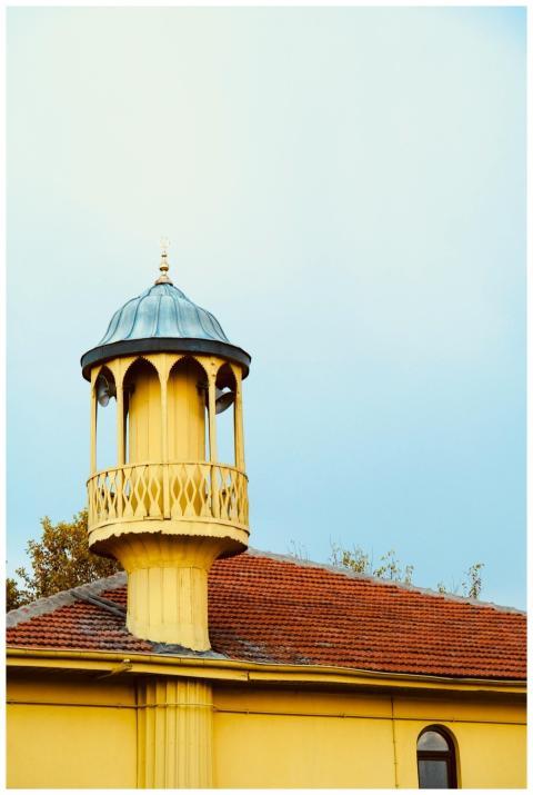 Yellow building with a round ornate tower featurin