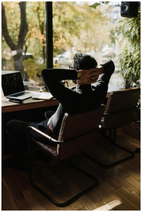 Adult man relaxing in a modern office chair, takin