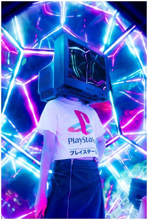 Person wearing retro TV as helmet surrounded by vi