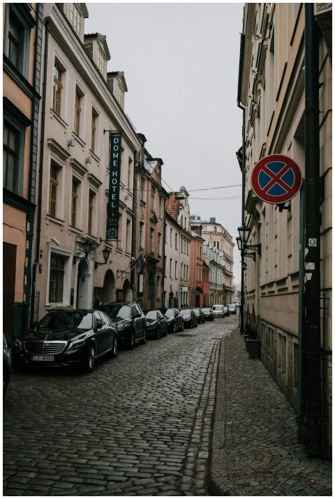 Explore a narrow cobblestone street lined with his