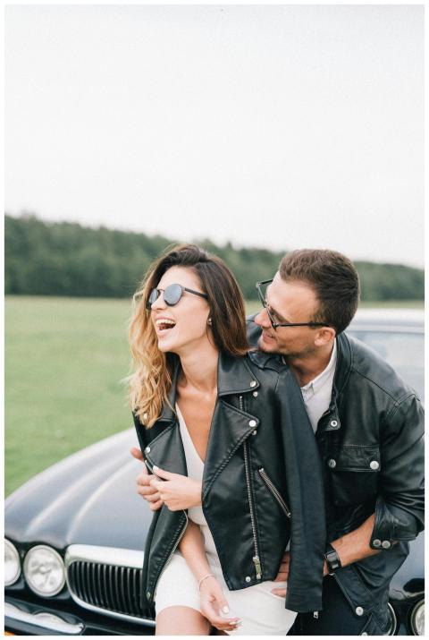 Young couple laughing together outdoors in stylish