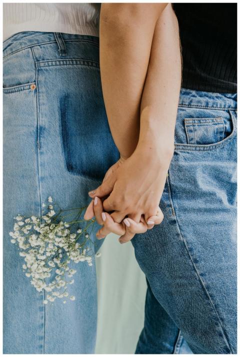 Close-up of a couple wearing denim jeans holding h