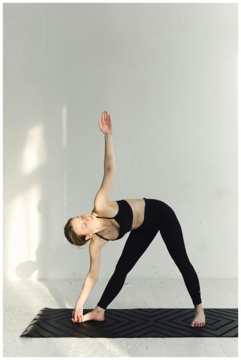 Woman in sportswear performing a yoga pose indoors