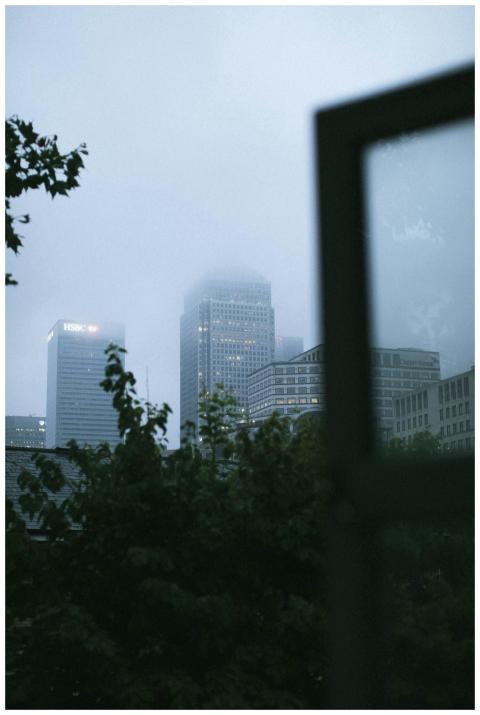 A moody cityscape with fog-covered skyscrapers and