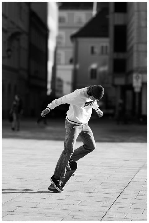 Young skateboarder performing a trick in a city sq