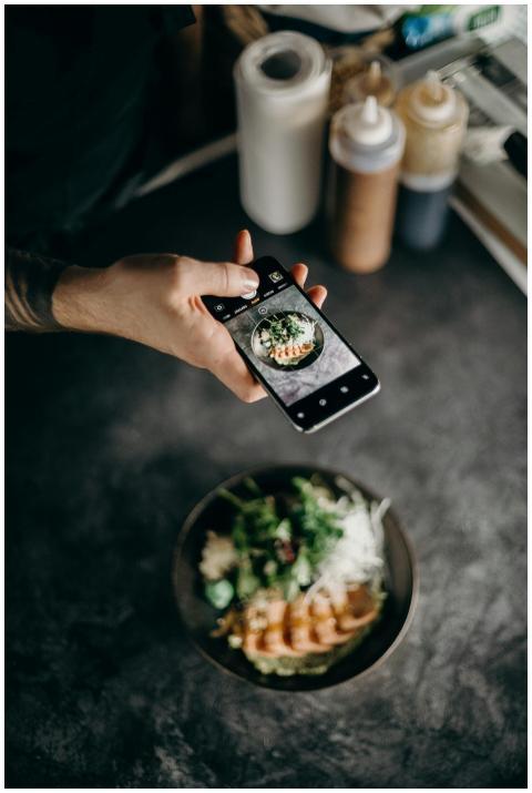 A person photographing a beautifully plated Asian