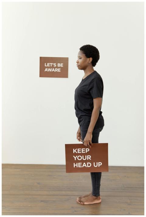 African American woman holds sign with an inspirin