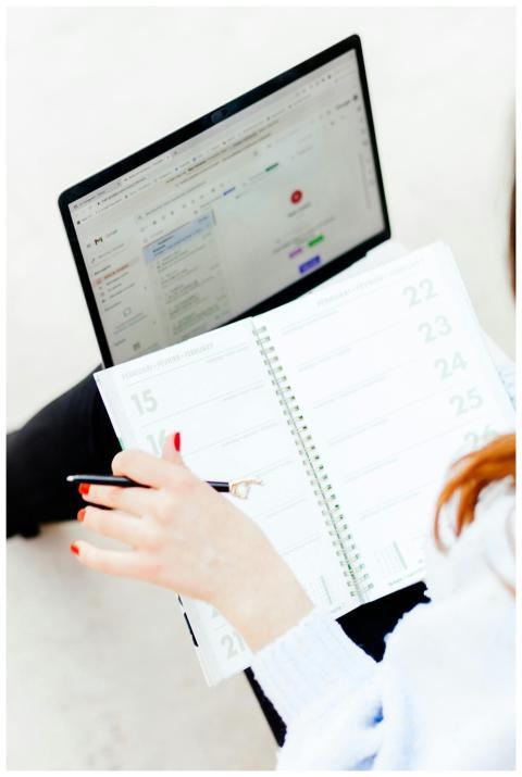 Woman using laptop and notebook for work organizat