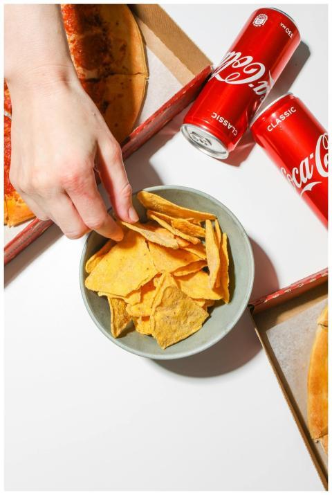 Top view of pizza, chips, and cold Coca-Cola. Idea