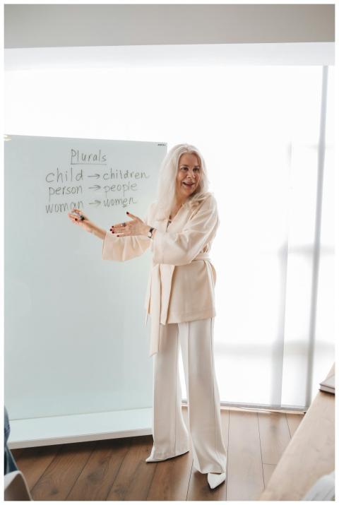 Elderly female instructor teaches English grammar