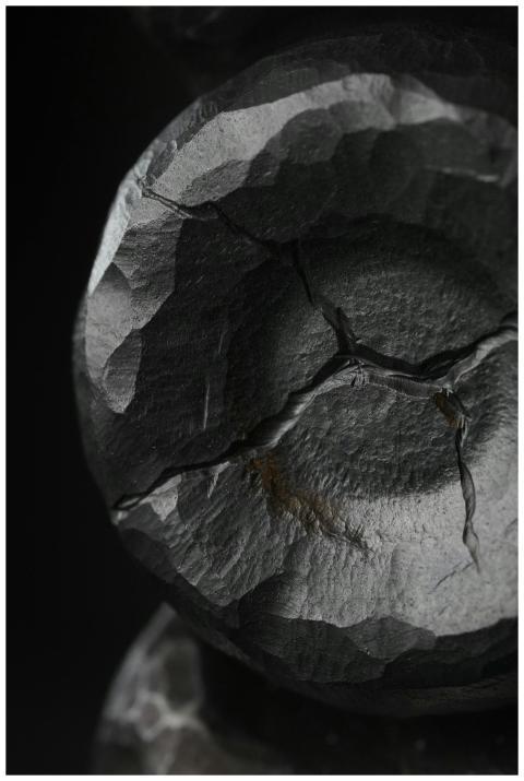 Detailed view of a cracked, textured black stone s