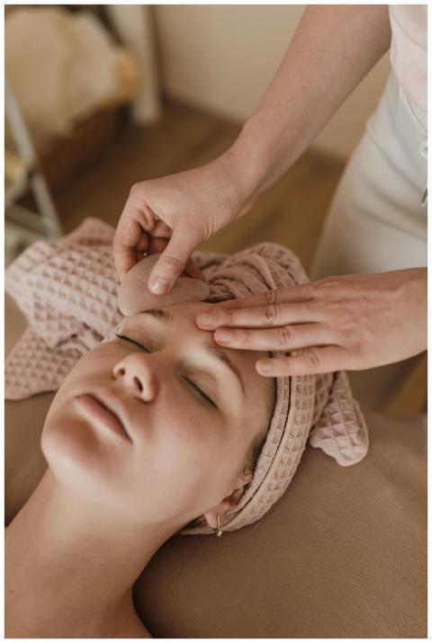 Woman enjoying a soothing facial massage with gua