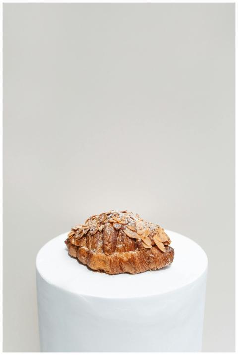 Delicious almond croissant with powdered sugar on