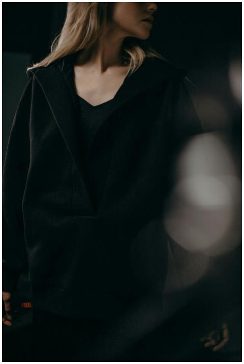 A woman with blonde hair in a dark minimalist outf