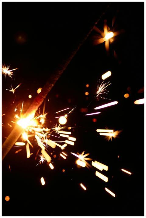 Close-up shot of a burning sparkler illuminating t