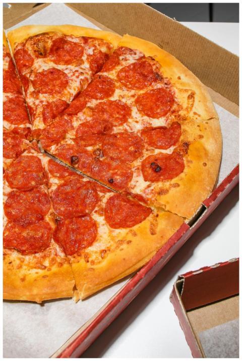 Freshly baked pepperoni pizza in an open cardboard