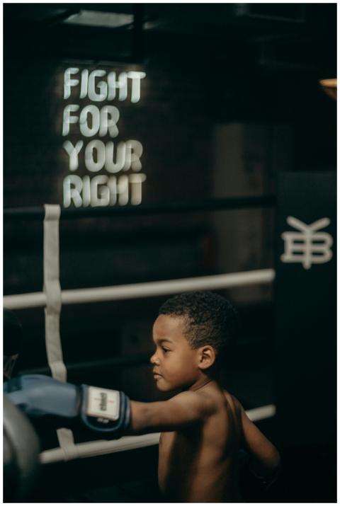Focused young boy throws a punch in a dimly lit bo