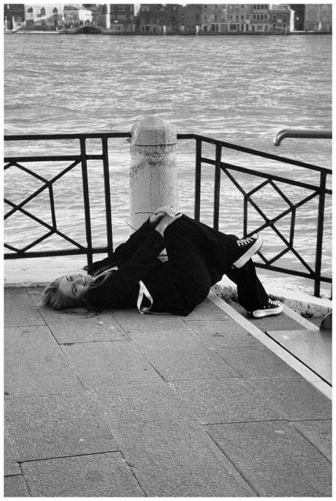 Casual moment of a woman lying near Venice waterfr