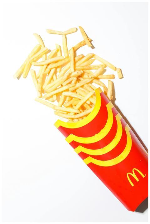 Golden crispy French fries spilling from iconic re