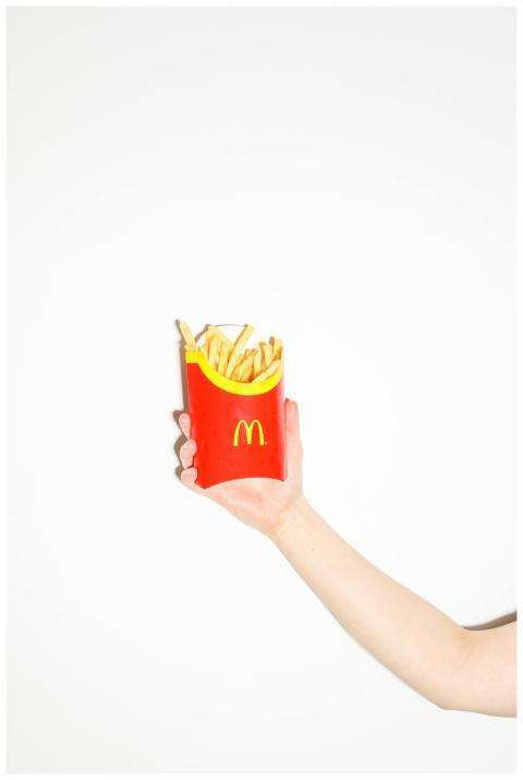 A person holding a McDonald's fries pack against a