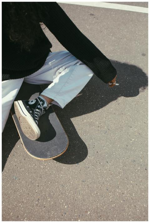 Urban street style featuring a skater sitting casu