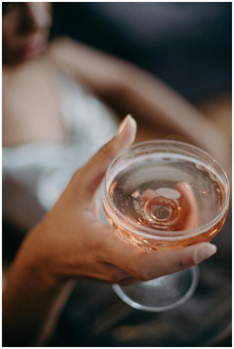 A close-up of a hand holding a cocktail glass fill