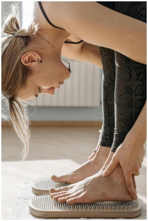 A woman performing a yoga pose on a sadhu acupress