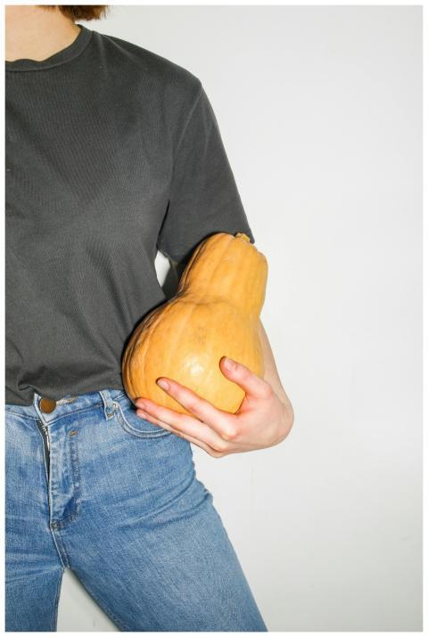 Close-up image of a person holding a butternut squ