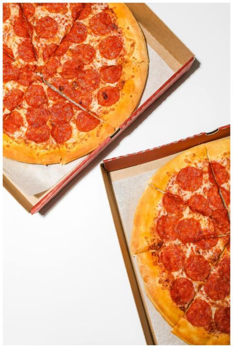 Top view of two pepperoni pizzas in cardboard boxe