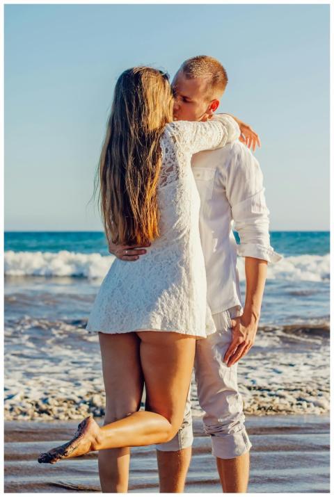 A couple sharing a romantic kiss by the ocean on a