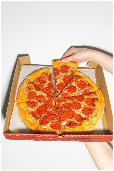 Close-up of a hand picking a slice of tasty pepper