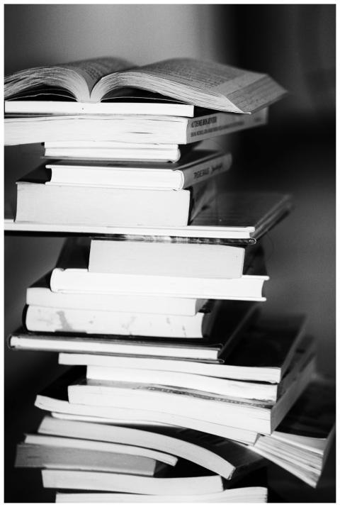 A monochrome image of a tall stack of books symbol