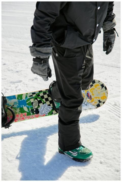 Snowboarder wearing winter gear stands with colorf