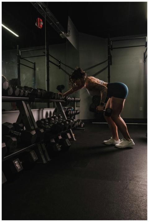 A woman performs a bent-over row with dumbbells in