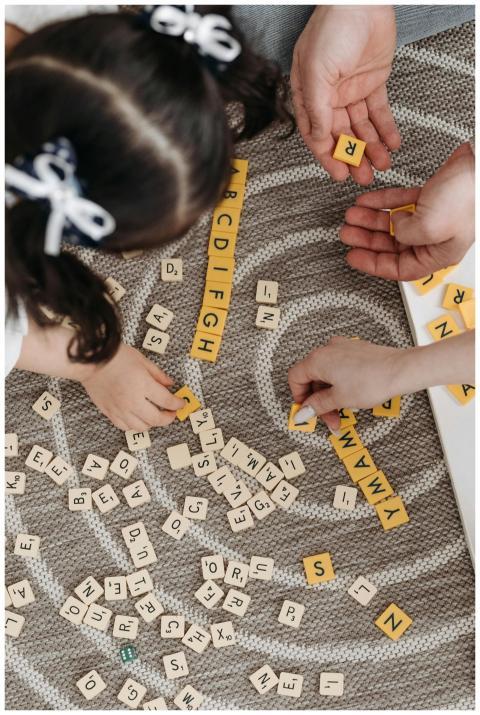Family playing a word game with tiles on a pattern