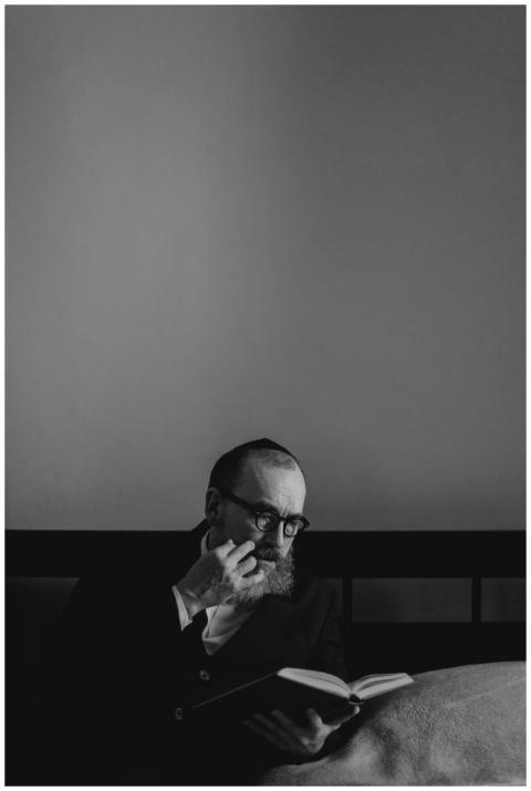 An Orthodox Jewish man with a beard and glasses, r