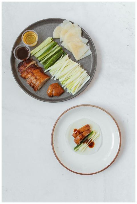 A flat lay of Peking duck with classic sides on a