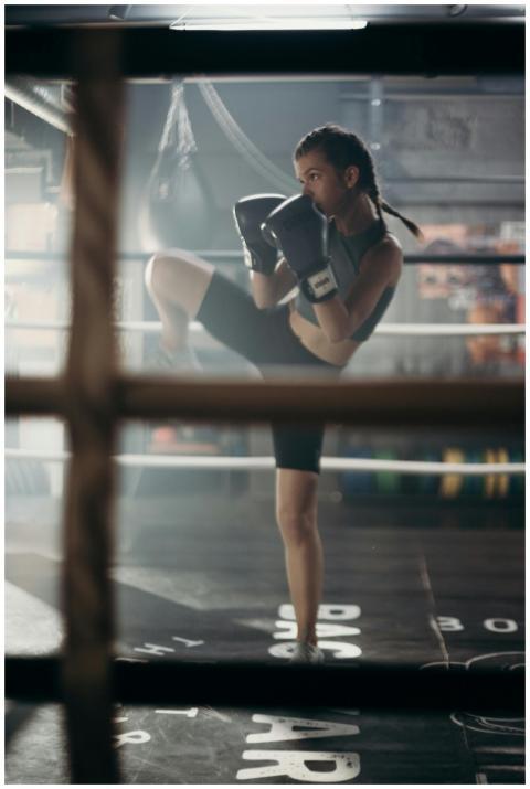 Determined young woman practicing kickboxing in a