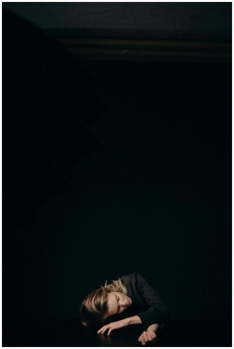 A serene portrait of a woman asleep against a dark