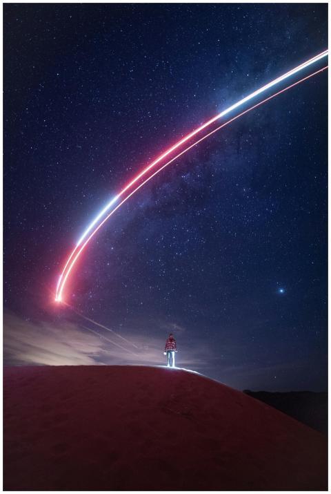 A person under a starry night sky with a striking