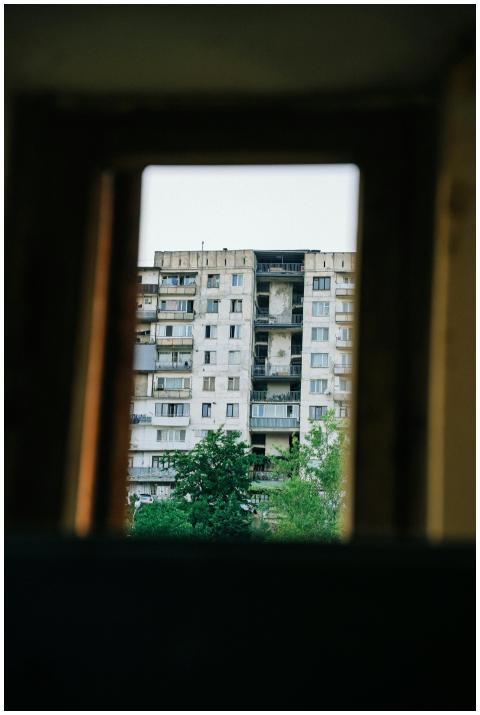 View of a decaying apartment building through a wi