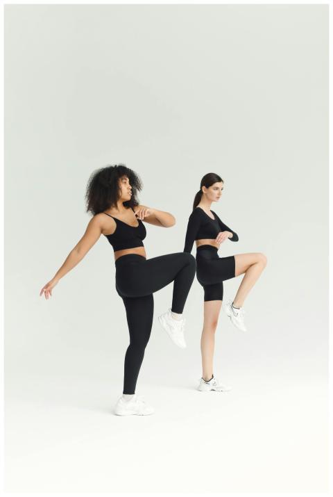 Two women perform fitness exercises in a minimalis