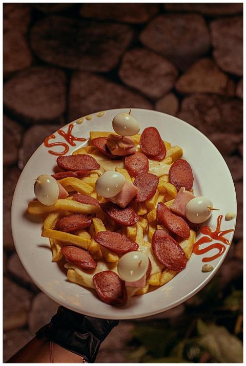 A mouthwatering plate of fries topped with sausage