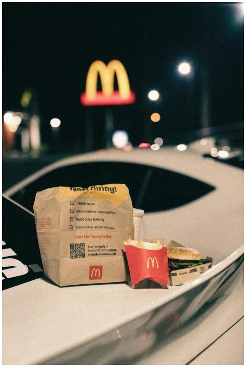 McDonald's takeout rests on a car hood with an ill