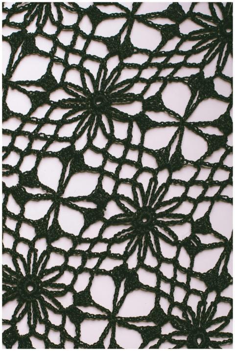 Detailed close-up of a black crochet lace with flo